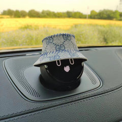 NOMI is wearing a white fisherman's hat with a light blue pattern printed on it.