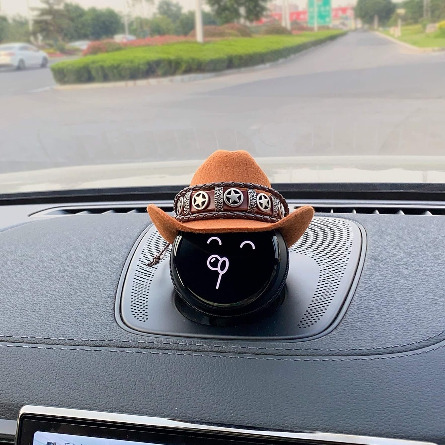 The cowboy hat is adorned with a copper star-shaped belt with a braided leather cord decorated above and below.