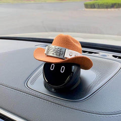 A floral embossed iron plate is fastened to the cowboy hat by a white leather belt.