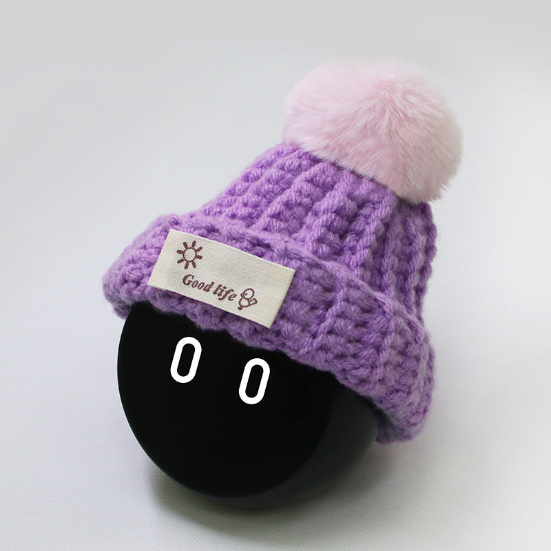 purple color beanie with pink furball.